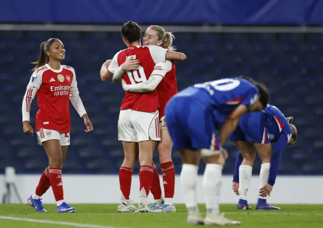 Arsenal players celebrate at full time as Chelsea players slump