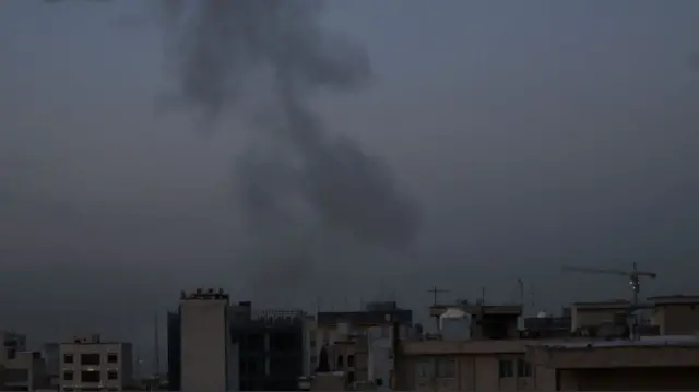 A cloud of black smoke emerges over a cluster of residential buildings in Tehran in the early hours of the morning