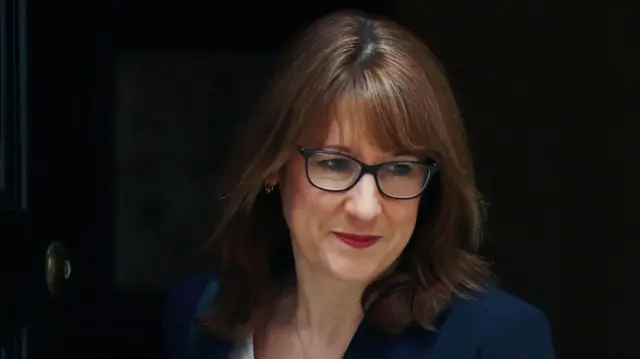 Chancellor Rachel Reeves, a woman with medium-length brown hair and glasses in a dark suit.