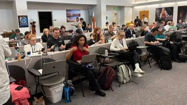 Rows of reporters with laptops out in front of them