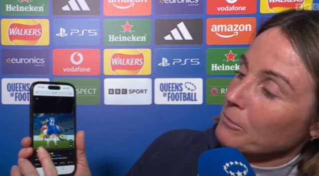 Bompastor shows her phone to the camera