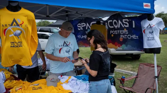 A man sells t-shirts ahead of the upcoming Artemis launch