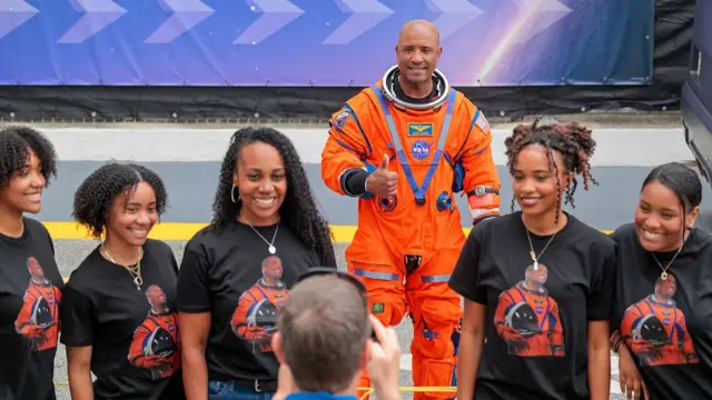 Pilot Victor Glover takes a photo with his family - putting his thumb up