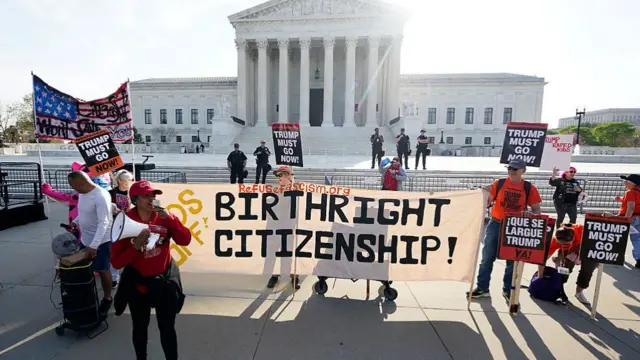 A group of protesters hold a large sign that says "Hands off Birthright Citizenship"