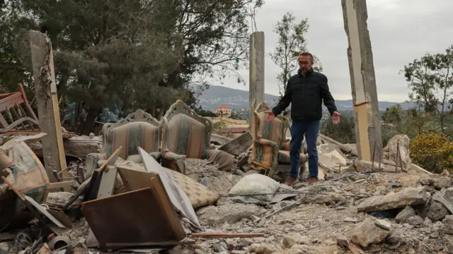 The mayor of Houmine El Tahta, Lebanon, gestures as he inspects the site of a house destroyed by an Israeli strike