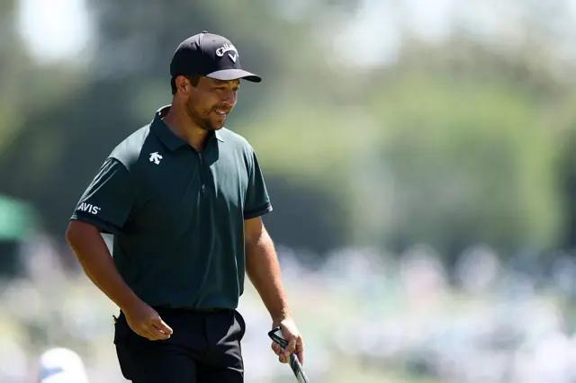 Xander Schauffele smiling after a putt