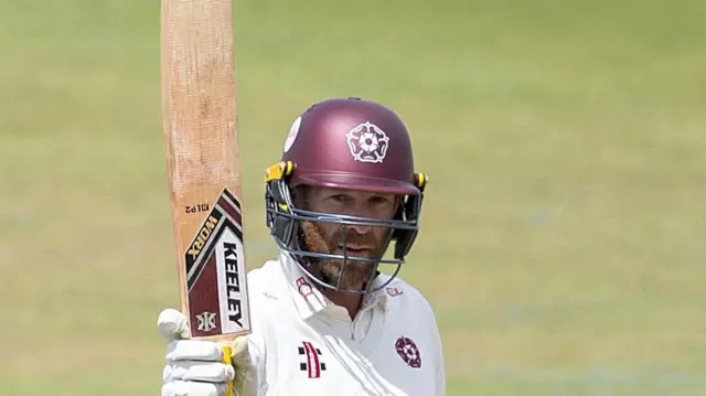 Luke Procter raising his bat for Northants