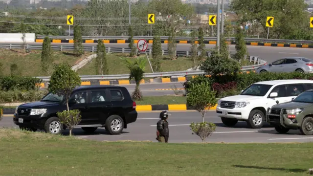 A Pakistani security official stands guard as vehicles carrying US officials pass following their arrival at Nur Khan Airbase, ahead of talks involving US and Iranian delegations in Islamabad, Pakistan, 10 April 2026