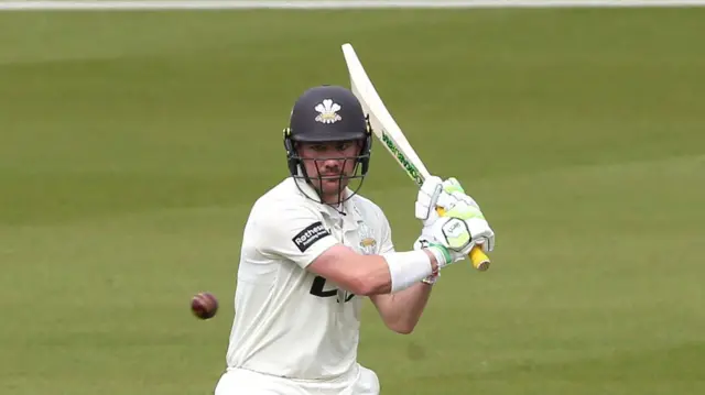 Rory Burns with his eyes on the ball and his bat held high up