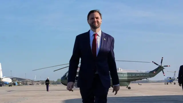 JD Vance walks away from a green US helicopter as he prepares to fly to Pakistan