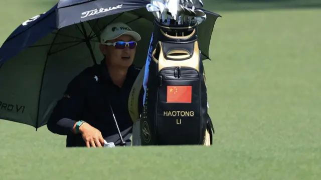 Li Haotong sheltering from the sun on hole two at Augusta National