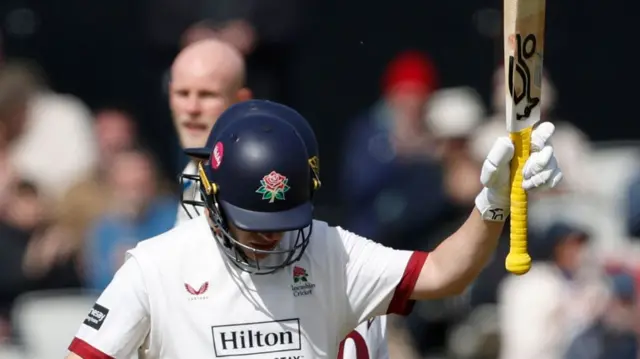 Marcus Harris raises his bat after passing 50 for Lancashire