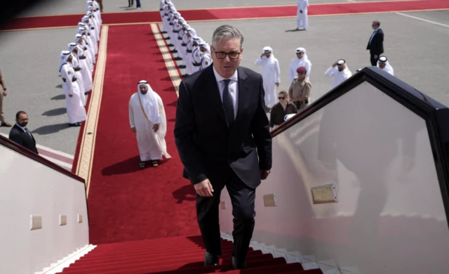 Britain's Prime Minister Keir Starmer boards a plane at the airport in Doha,
