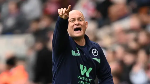 Millwall manager Alex Neil shouts and points one finger upwards on the touchline