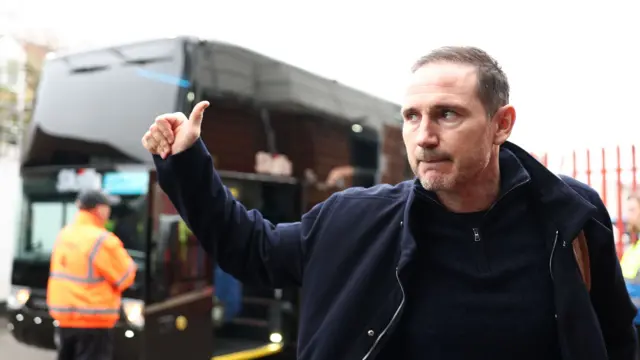 Frank Lampard gives a thumbs up while looking back at a bus