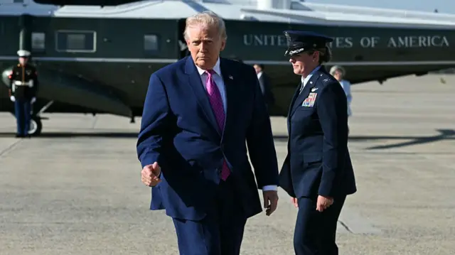 ट्रम्प एक सैन्य हेलीकॉप्टर छोड़ते हैं और वायु सेना 1 की ओर चलने से पहले प्रेस कैमरों को थम्स अप देते हैं