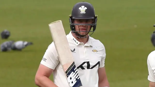 Jamie Smith with his bat raised for Surrey