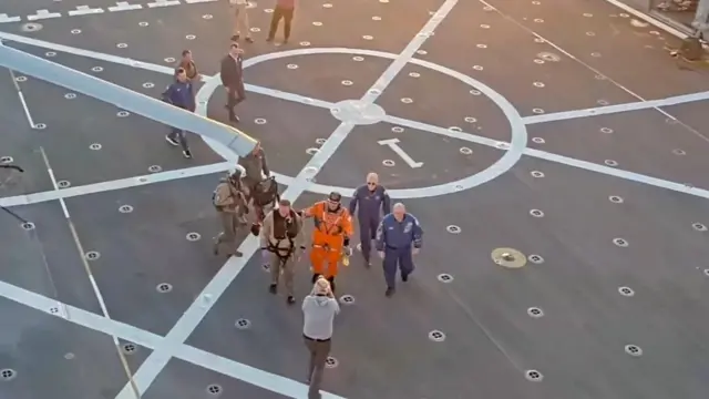 A crew member walks across the deck