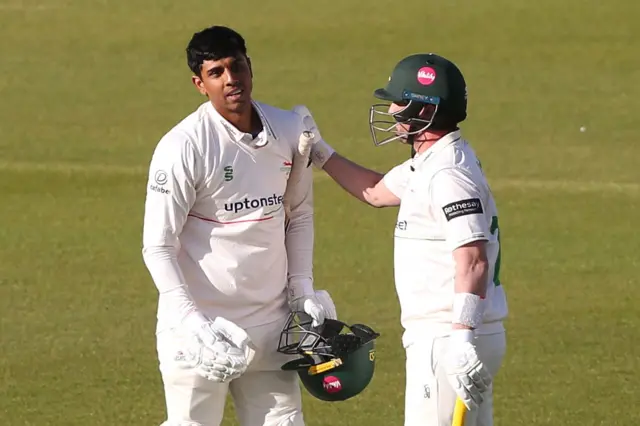 Rishi Patel celebrates his hundred with Leics team-mate Lewis Hill