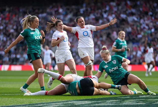Jess Breach of England scores her team's fourth try whilst being tackled by Vicky Elmes Kinlan of Ireland