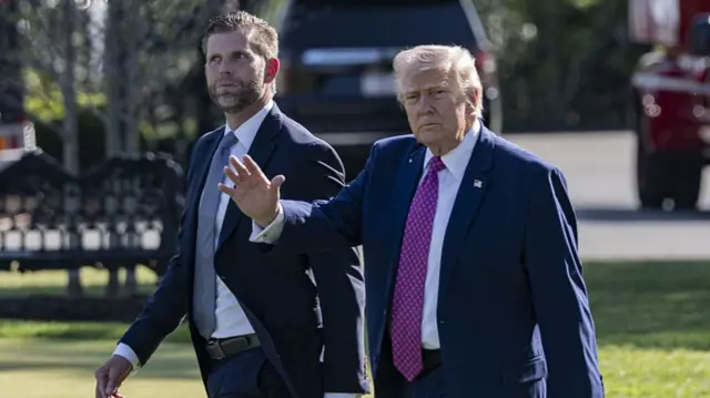 US President Donald Trump (R) and his son Eric Trump (L) depart the White House.