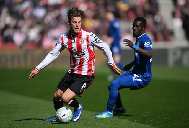 Mathias Jensen of Brentford controls the ball under pressure from Idrissa Gueye of Everton