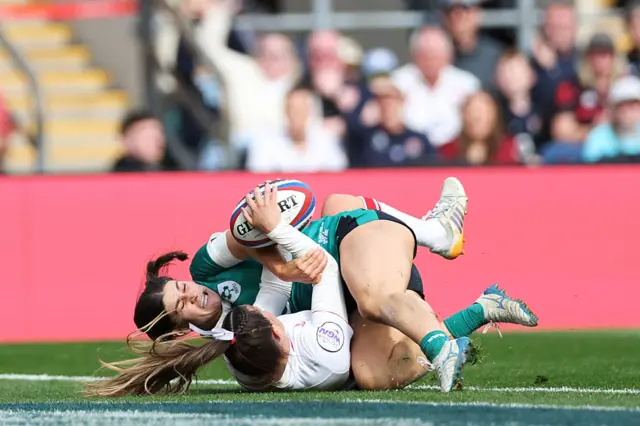 Jess Breach of England scores her team's fourth try whilst being tackled by Vicky Elmes Kinlan of Ireland