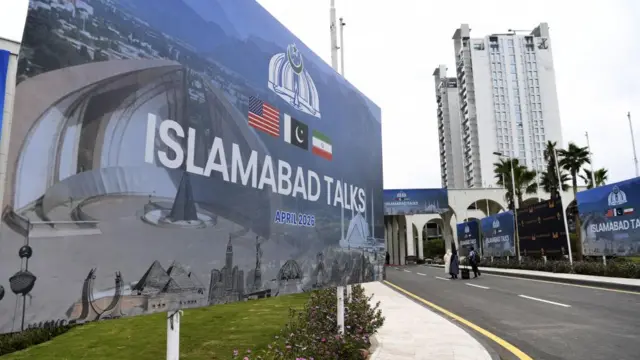 A blue billboard on a street corner in Islamabad that reads 'Islamabad talks'.