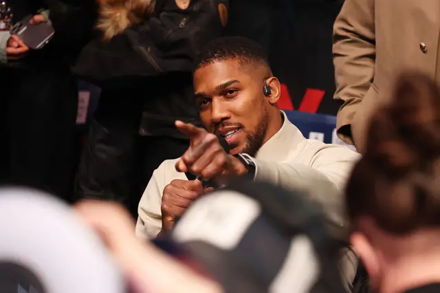 Anthony Joshua speaks into a microphone and points his finger