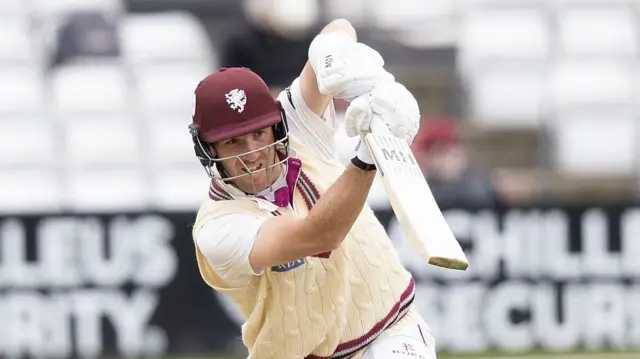 Craig Overton, batting and wearing a sleeveless cable-knit sweater, playing a stroke for Somerset