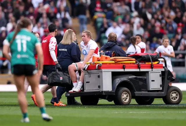 Morwenna Talling of England is driven off the pitch by medical staff after sustaining an injury