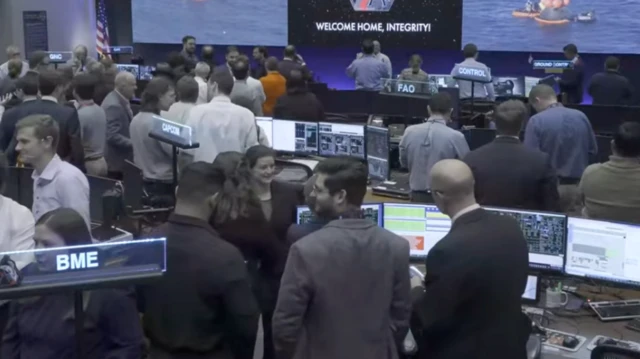 Flight controllers stand around chatting