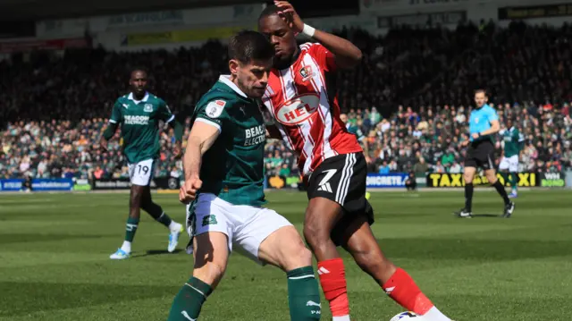Joe Edwards of Plymouth Argyle battles for the ball with Carlos Mendes Gomes of Exeter City