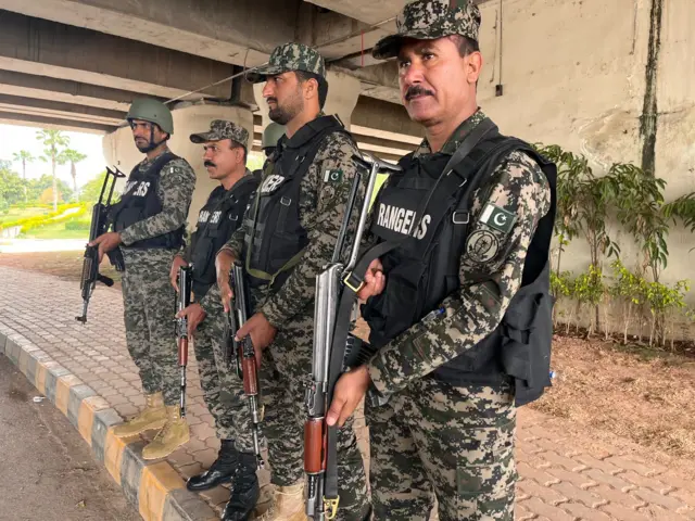 Armed guards in Pakistan stand at a checkpoint.