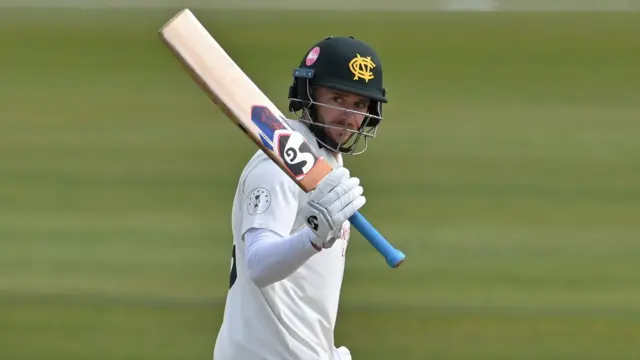 Notts batter Joe Clarke raises his bat after getting 50 against Glamorgan