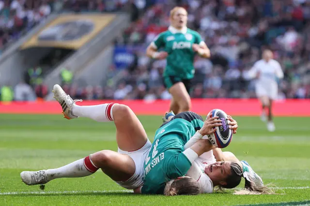 Jess Breach of England scores her team's fourth try whilst being tackled by Vicky Elmes Kinlan of Ireland