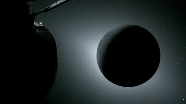 The moon appears completely dark with sunlight appearing around its edge