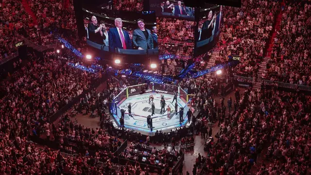 US President Donald Trump and Hunter Campbell, CBO of UFC, are seen on the screens at UFC 327 at Kaseya Center.