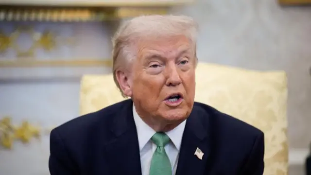 Donald Trump sits in the Oval Office