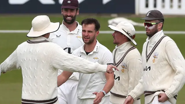 Surrey players congratulate Tom Lawes (in the middle)