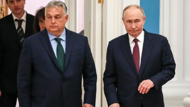 Hungarian Prime Minister Viktor Orbán and Russian President Vladimir Putin, both wearing suits. Orbán is wearing a dark green tie and Putin is wearing a red one.