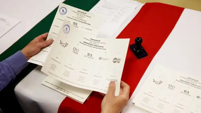 A voting slip is examined by someone at a polling station in Hungary
