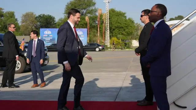 JD Vance walks towards two security guards by the stairs to Air Force Two after peace talks in Pakistan