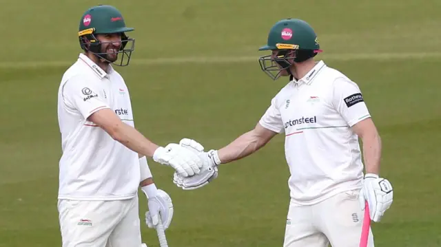 Stevie Eskinazi and Ben Cox shaking hands while batting together