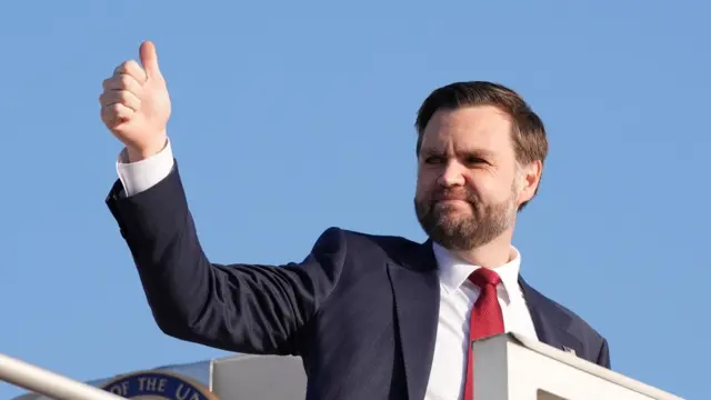 U.S. Vice President JD Vance gestures as he boards Air Force Two.