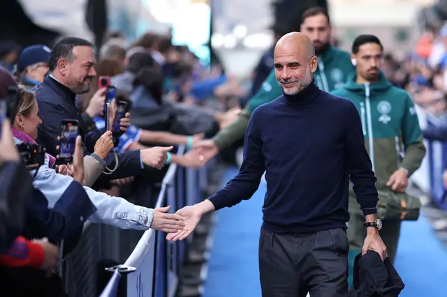 Guardiola smiles as he arrives at Stamford Bridge