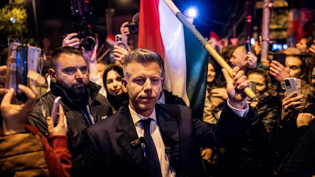 Peter Magyar, leader of the Tisza party, carries a Hungarian flag