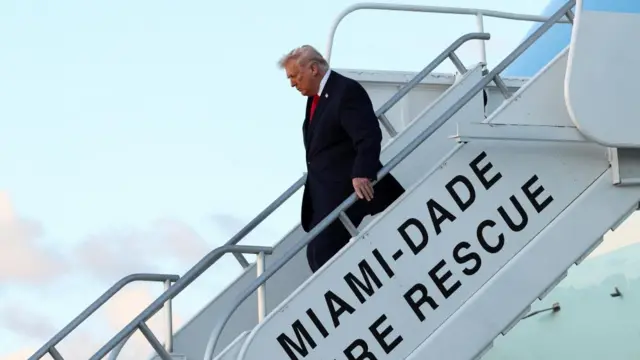 Donald Trump walks down some stairs next to Air Force One in Miami