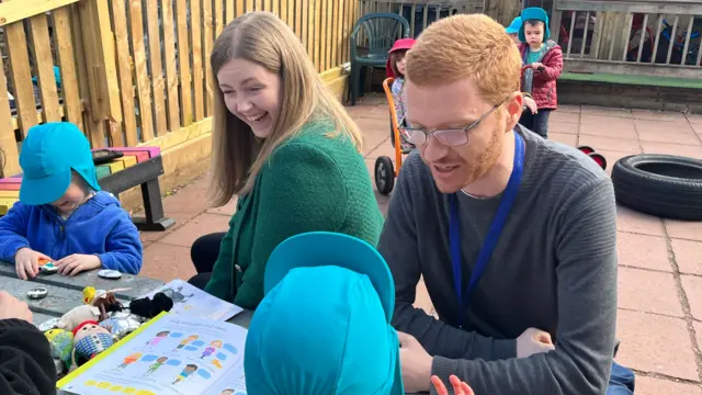 Scottish Greens co-leaders Gillian Mackay and Ross Greer sit in an outdoor play area talking to young children