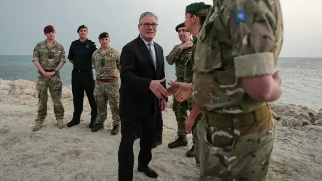 Britain's Prime Minister Keir Starmer meets military personnel on a beach in Bahrain, April 9